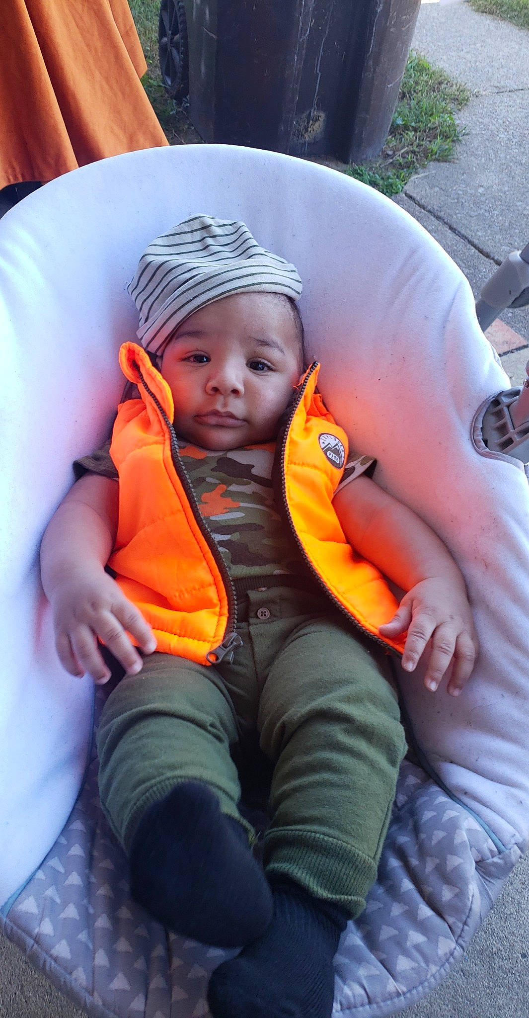 Cevynn joined the competition — help win amazing prizes! baby, baby_carriage, baby_products, baby_safety, baby_toddler_clothing, beanie, cheek, child, comfort, fun, grass, lap, leisure, orange, person, plant, recreation, sitting, thumb, toddler