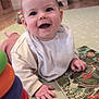 baby, bib, child, clothing, colorful, cute, face, floor, furniture, hand, happy, home, indoors, infant, playmat, playtime, puzzle, smiling, toys, wooden