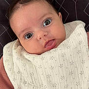 Ilhem participe au concours pour gagner de l'argent avec cette photo : baby, bib, child, close_up, clothing, cute, eyes, fabric, face, head, indoors, infant, pattern, person, pink, portrait, skin, tongue, white, young