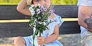 Ambre a rejoint le concours — aidez-le/la à gagner de superbes lots ! arm, bench, blue_eyes, casual, child, cute, dress, flowers, footwear, hat, nature, outdoor, person, portrait, sitting, striped_dress, summer, sunny, tattoo, wildflowers