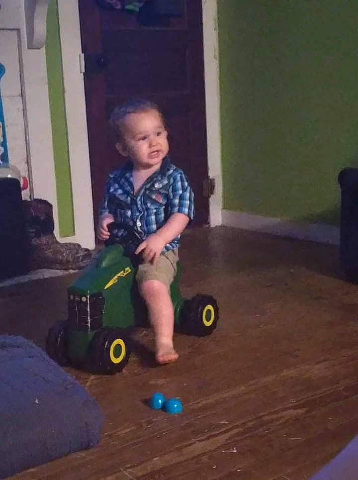 Atlas is registered to the contest to win money with this photo: child, door, electric_blue, floor, flooring, fun, happy, hardwood, person, riding_toy, rolling, sitting, tints_and_shades, tire, toddler, toy, toy_vehicle, varnish, wheel, wood