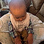 Kace Ray Lewis is registered to the contest to win money with this photo: toddler, baby, indoor, plaid_shirt, bib, little_man, cushion, baby_seat, shoes, hands, head, window, curtains, pillow, fabric, clothing, child, person, soft_light, cozy