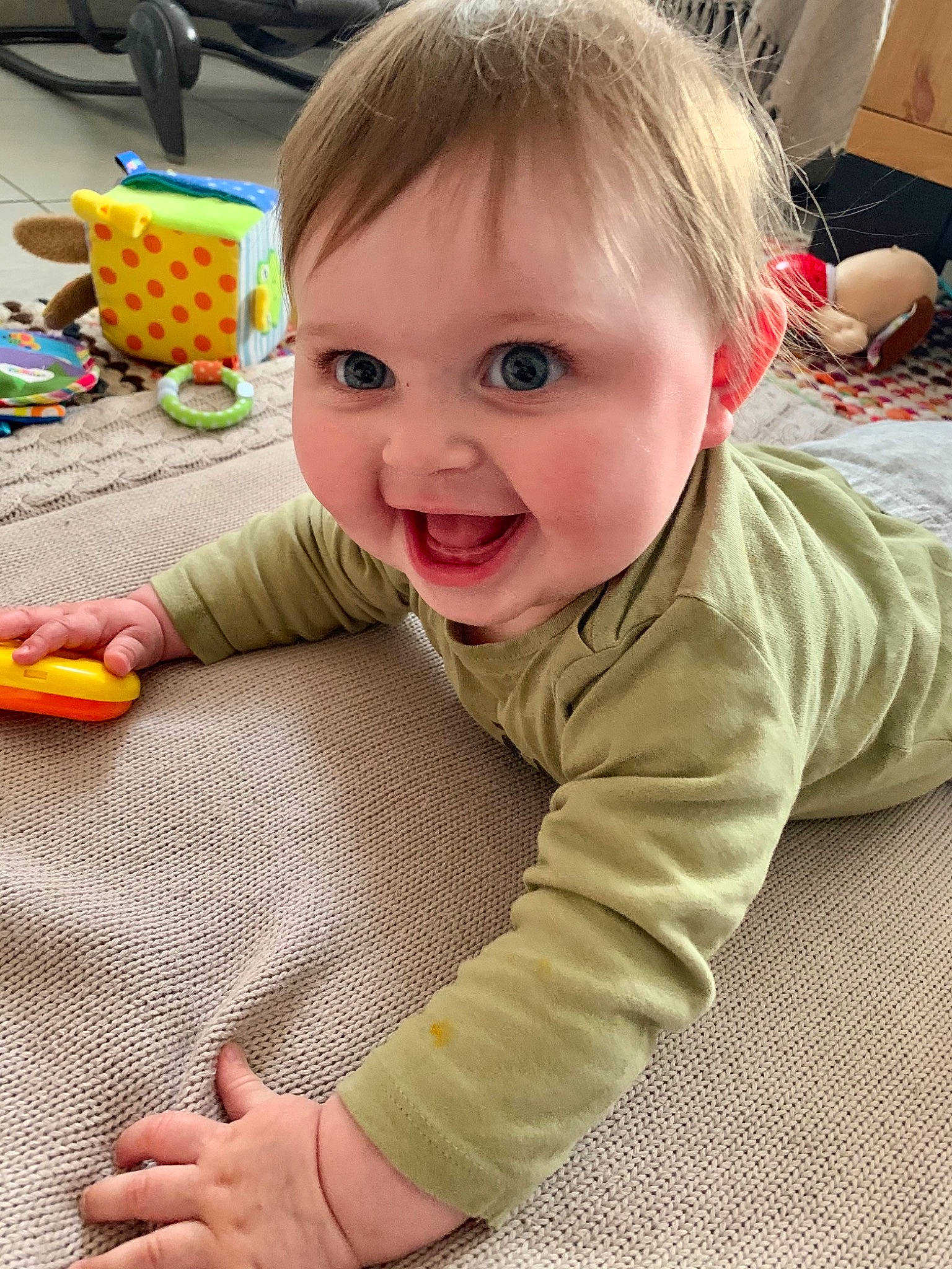 Lola participe au concours pour gagner de l'argent avec cette photo : baby, baby_playing_with_toys, baby_products, baby_toddler_clothing, cheek, child, face, flooring, fun, hair, happy, nose, person, play, room, sitting, skin, sleeve, smile, toddler