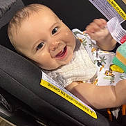 Luka joined the competition — help win amazing prizes! baby, car_seat, smile, child, infant, bib, toy, happy, indoor, seat, clothing, person, cute, face, expression, young_child, sitting, bright, playful, comfort