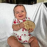 Luka is registered to the contest to win money with this photo: baby, child, smiling, happy, sitting, plaque, wooden, clothing, crab_pattern, onesie, blanket, indoor, face, hands, cute, infant, portrait, skin, person, baby_girl