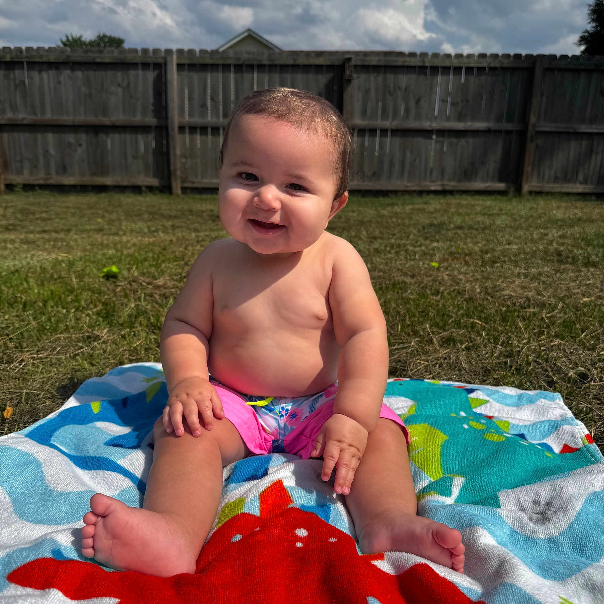 Luka is registered to the contest to win money with this photo: baby, child, smiling, outdoor, grass, towel, sunlight, happy, barefoot, summer, fence, nature, portrait, cute, sitting, skin, head, expression, daytime, playful