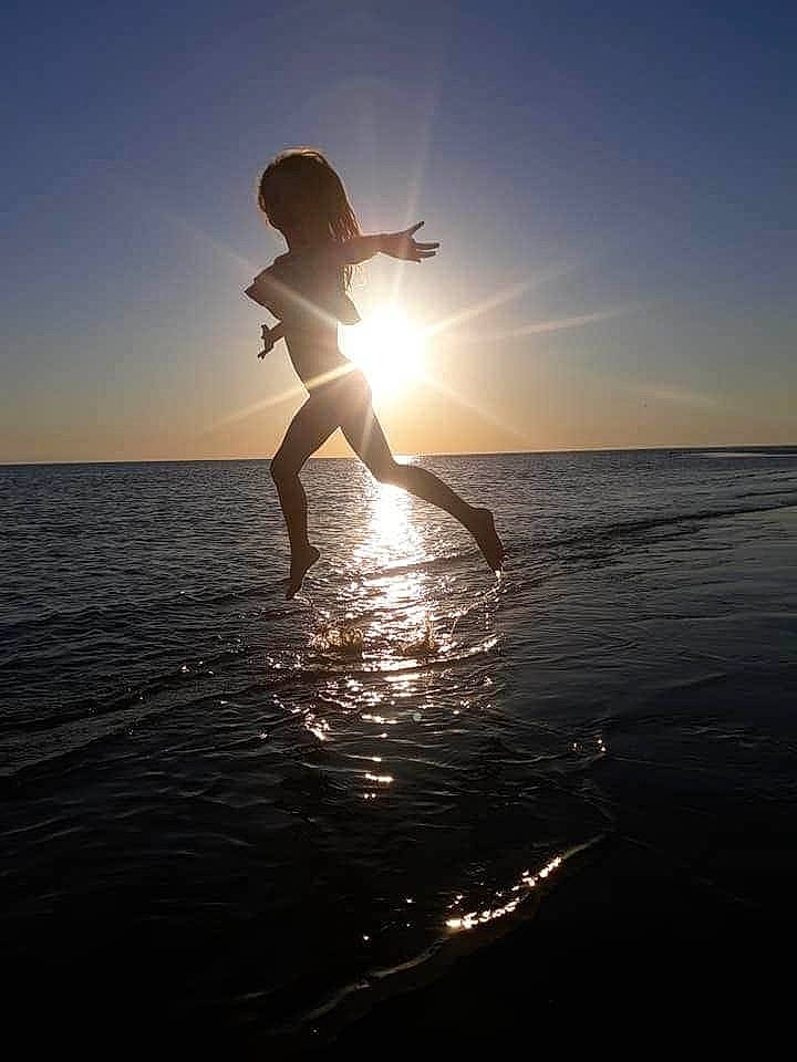 Savanah is registered to the contest to win money with this photo: backlighting, beach, calm, cloud, fun, happy, horizon, jumping, morning, ocean, photography, sea, sky, summer, sun, sunlight, sunrise, sunset, vacation, water