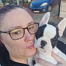 woman, person, puppy, dog, french_bulldog, black_and_white, pet, animal, cuddle, selfie, glasses, piercing, face, ears, portrait, outdoor, driveway, car, residential, hand