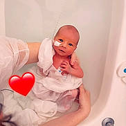 Nathao participe au concours pour gagner de l'argent avec cette photo : newborn, baby, infant, bathtub, water, adult_hands, medical_tape, hospital, white_fabric, heart_emoji, skin, person, care, love, fragile, portrait, closeup, bath, gentle, tender
