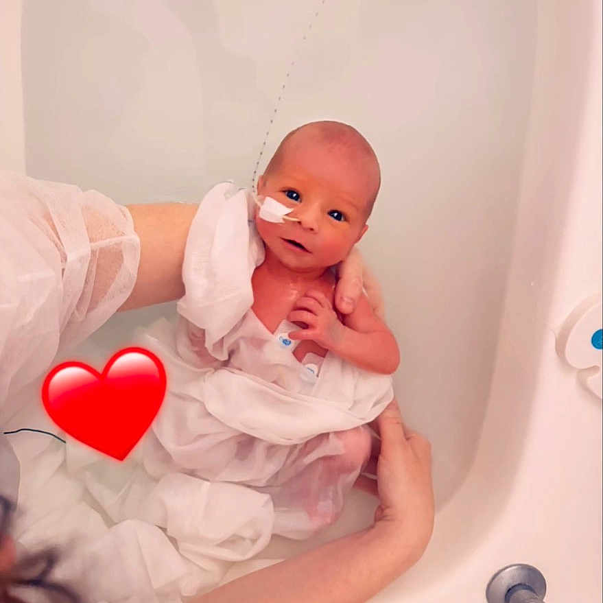 Nathao participe au concours pour gagner de l'argent avec cette photo : newborn, baby, infant, bathtub, water, adult_hands, medical_tape, hospital, white_fabric, heart_emoji, skin, person, care, love, fragile, portrait, closeup, bath, gentle, tender