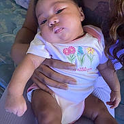 Jaliyah joined the competition — help win amazing prizes! baby, infant, person, child, clothing, onesie, socks, hand, arm, bed, blanket, skin, face, portrait, sleepy, indoor, cuddle, holding, relaxed, cute