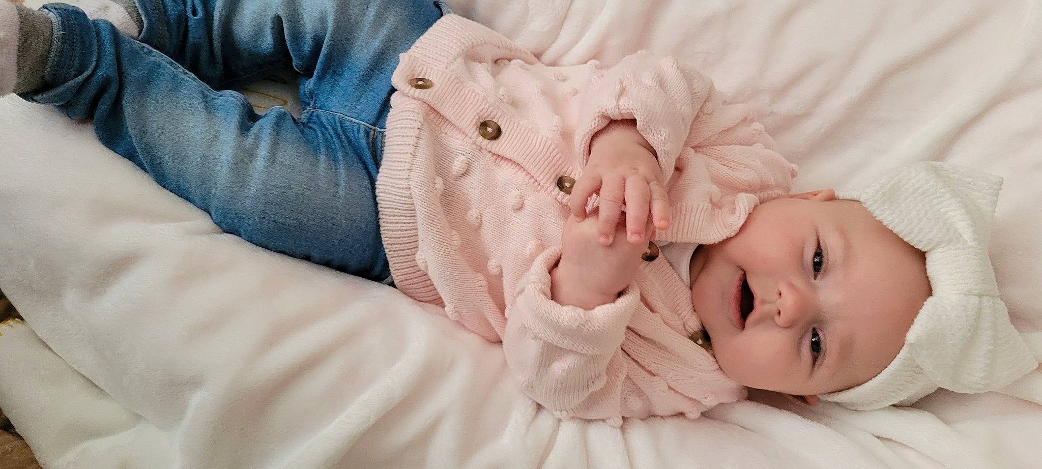Arya is registered to the contest to win money with this photo: arm, baby, baby_toddler_clothing, cheek, child, comfort, eye, eyelash, finger, gesture, hand, happy, headwear, lip, nail, person, sitting, skin, sleeve, textile