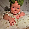 Averi joined the competition — help win amazing prizes! baby, child, infant, portrait, smiling, face, blue_eyes, green_bow, headband, floral_cushion, bed, blanket, hands, outdoor, indoor, closeup, sitting, happy, carpet, photography
