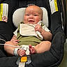 Averi is registered to the contest to win money with this photo: baby, infant, child, smiling, portrait, car_seat, safety_harness, bib, green_clothing, white_clothing, bare_feet, hospital_bracelet, seated, indoors, close_up, face, hands, toes, happy, photography