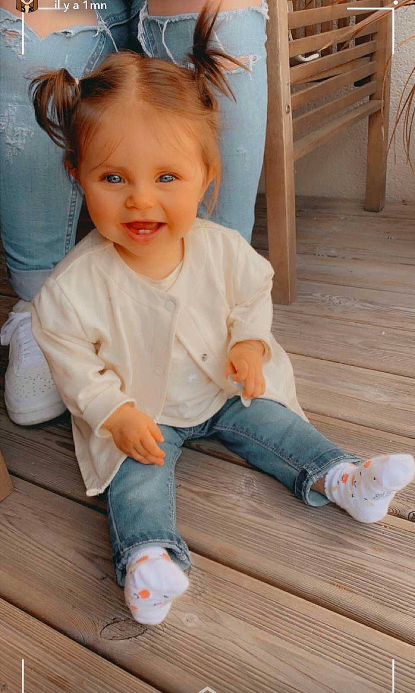 Louna participe au concours pour gagner de l'argent avec cette photo : baby_toddler_clothing, chair, cheek, child, eye, floor, flooring, foot, hair, happy, hardwood, human_leg, person, sitting, skin, sleeve, smile, sock, toddler, white