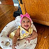 Leilani joined the competition — help win amazing prizes! baby, infant, smiling, pink_headband, yellow_bib, inflatable_seat, bear_pattern, wooden_floor, wooden_cabinet, happy, cute, indoors, child, person, foot, hand, headwear, playful, home, bright