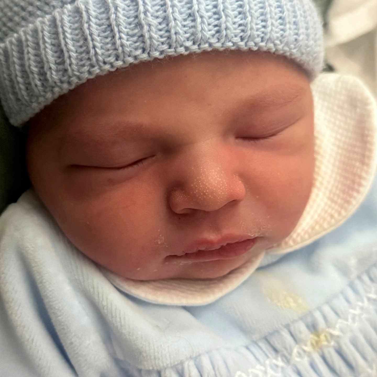 Jean participe au concours pour gagner de l'argent avec cette photo : newborn, baby, sleeping, hat, knitted_hat, blue_clothing, infant, face, close_up, peaceful, soft_lighting, cute, child, portrait, resting, skin_texture, indoors, cozy, newborn_clothes, baby_boy