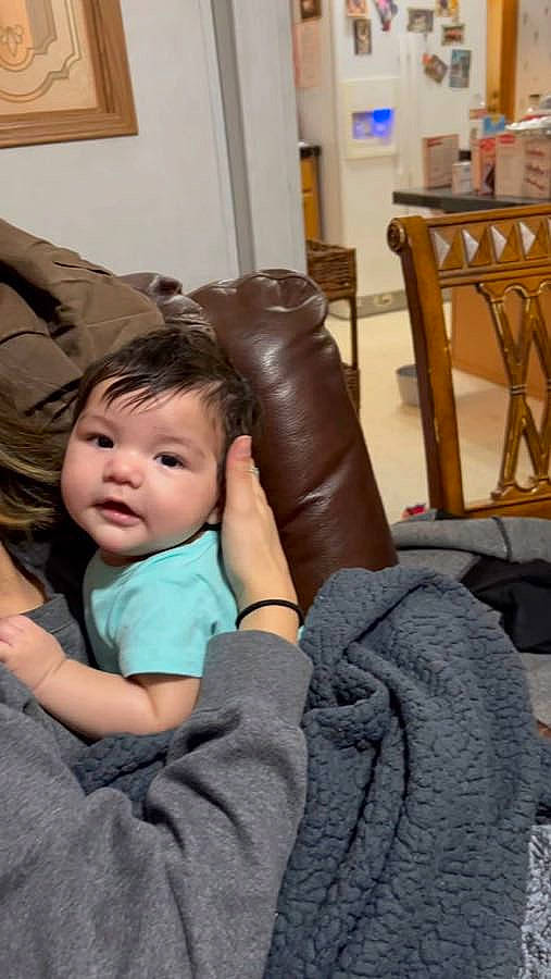 Eli joined the competition — help win amazing prizes! baby, chair, cheek, comfort, couch, event, finger, fun, furniture, gesture, hair, hand, happy, lap, living_room, person, picture_frame, room, sitting, thumb