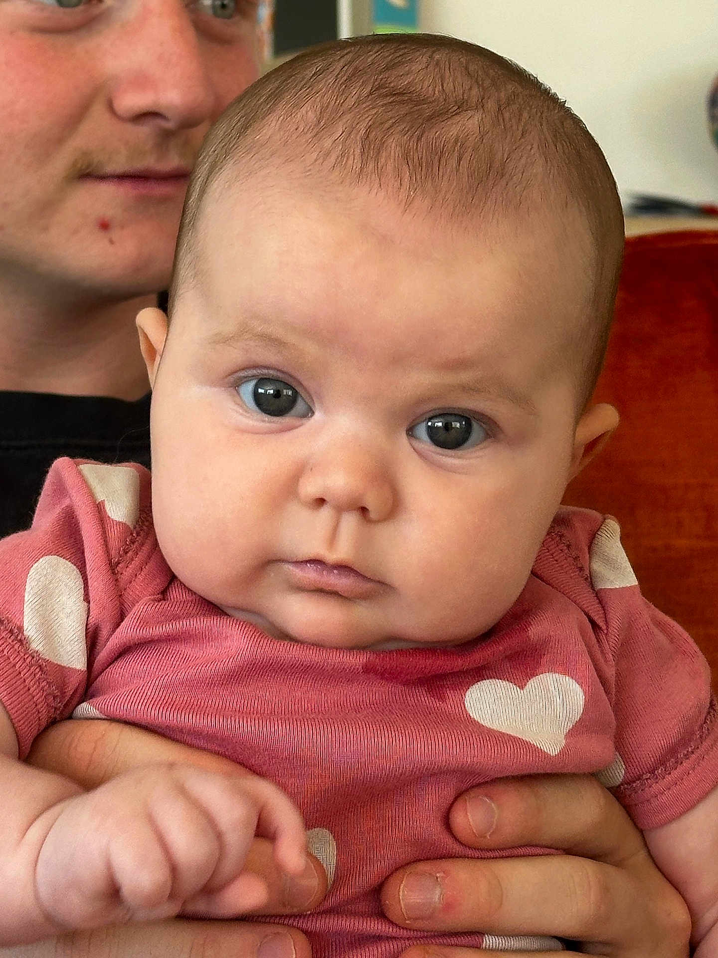 Roma participe au concours pour gagner de l'argent avec cette photo : baby, infant, person, face, adult, holding, hand, pink_clothing, heart_pattern, close_up, portrait, indoor, skin, expression, child, cute, eyes, young, family, love