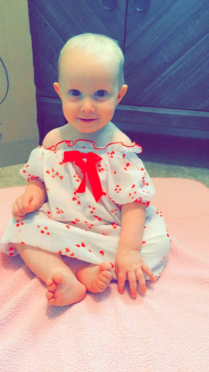 Islah is registered to the contest to win money with this photo: baby, baby_toddler_clothing, cheek, child, head, joy, leg, person, pink, play, sitting, skin, smile, toddler