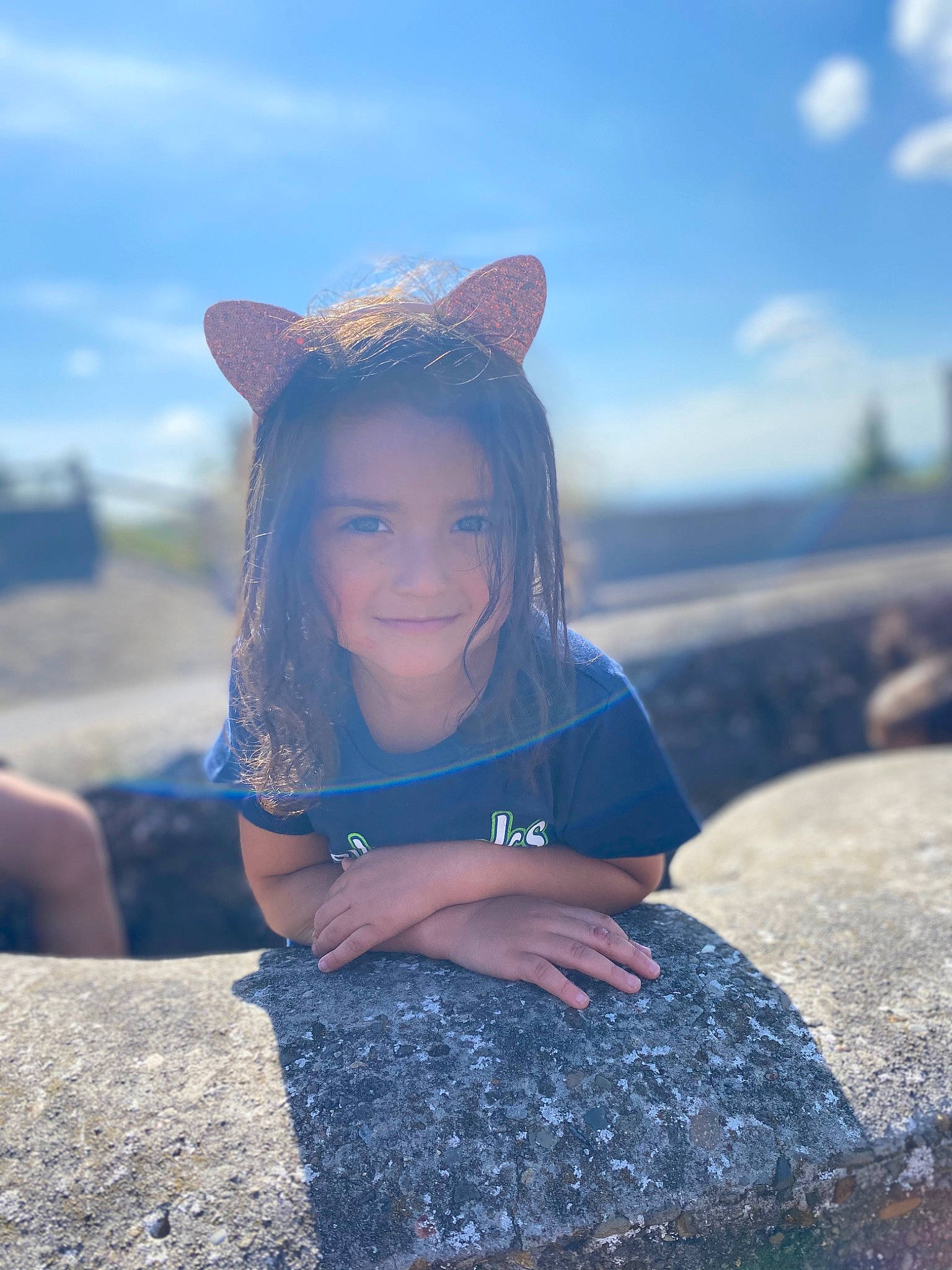 Tessa joined the competition — help win amazing prizes! beauty, blue, child, cloud, dress, ear, eye, fashion, head, joy, long_hair, mountain, person, photography, rock, sitting, skin, sky, smile, summer