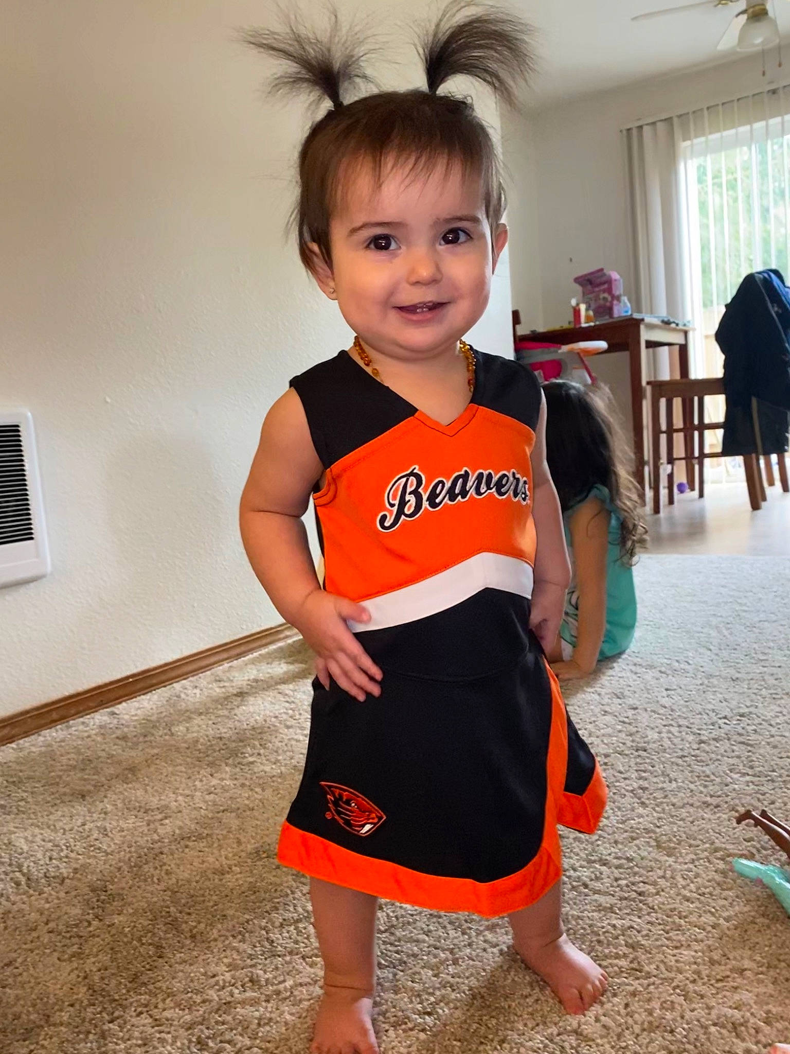 Jayde is registered to the contest to win money with this photo: arm, child, clothing, dress, face, head, human_leg, joint, joy, leg, neck, orange, person, personal_protective_equipment, shoulder, skin, sleeve, smile, standing, t_shirt