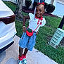 child, girl, smiling, outdoor, sidewalk, grass, car, tree, bushes, house, purse, fashion, red_bow, braids, sneakers, skirt, bracelet, happy, portrait, casual