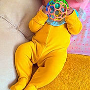 Charlene joined the competition — help win amazing prizes! baby, blanket, bright_colors, child, closeup, colorful_toy, couch, cozy, curly_hair, cute, indoor, infant, pink_pillow, playful, portrait, relaxed, smiling_eyes, soft_texture, toy, yellow_onesie