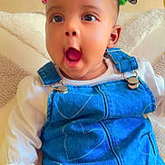 Charlene joined the competition — help win amazing prizes! baby, child, denim_overalls, white_shirt, hair_ties, colorful_hair, indoor, couch, pillow, expression, cute, infant, skin, hand, sitting, portrait, clothing, face, happy, person