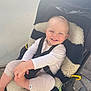 baby, smile, stroller, blanket, child, happy, outdoor, clothing, legs, seat, babywear, face, infant, cute, person, baby_toddler, sunlight, playful, joy, comfort