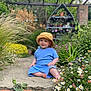 toddler, child, blue_clothing, bucket_hat, barefoot, garden, flowers, greenery, pathway, outdoor, plants, nature, smiling, sitting, daylight, pot_plants, rustic_shelf, colorful, cute, portrait