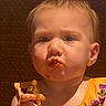 Skylar is registered to the contest to win money with this photo: toddler, child, food, eating, messy, face, expression, brown_background, yellow_clothing, sauce, hand, portrait, indoor, young_child, closeup, cute, person, appetite, snack, dining