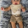 baby, infant, smiling, happy, lying_down, fluffy_rug, gray_fur, beige_clothing, bandana_bib, shorts, cute, child, indoors, soft_texture, portrait, skin, head, hands, feet, comfortable