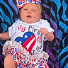 baby, infant, bow, headband, clothing, blanket, patterned_blanket, face, legs, feet, american_flag, cute, celebration, 4th_of_july, summer, portrait, child, newborn, lying_down, colorful