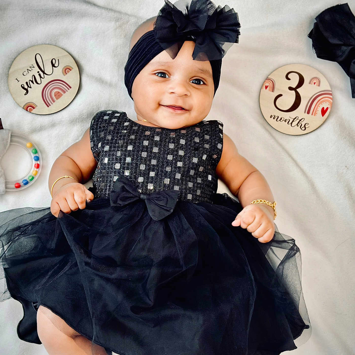 Aleyna Fella is registered to the contest to win money with this photo: accessory, baby, black_dress, blanket, bracelet, child, closeup, cute, decor, happy, headband, infant, lying_down, milestone, plaque, playful, portrait, smile, toy, tulle