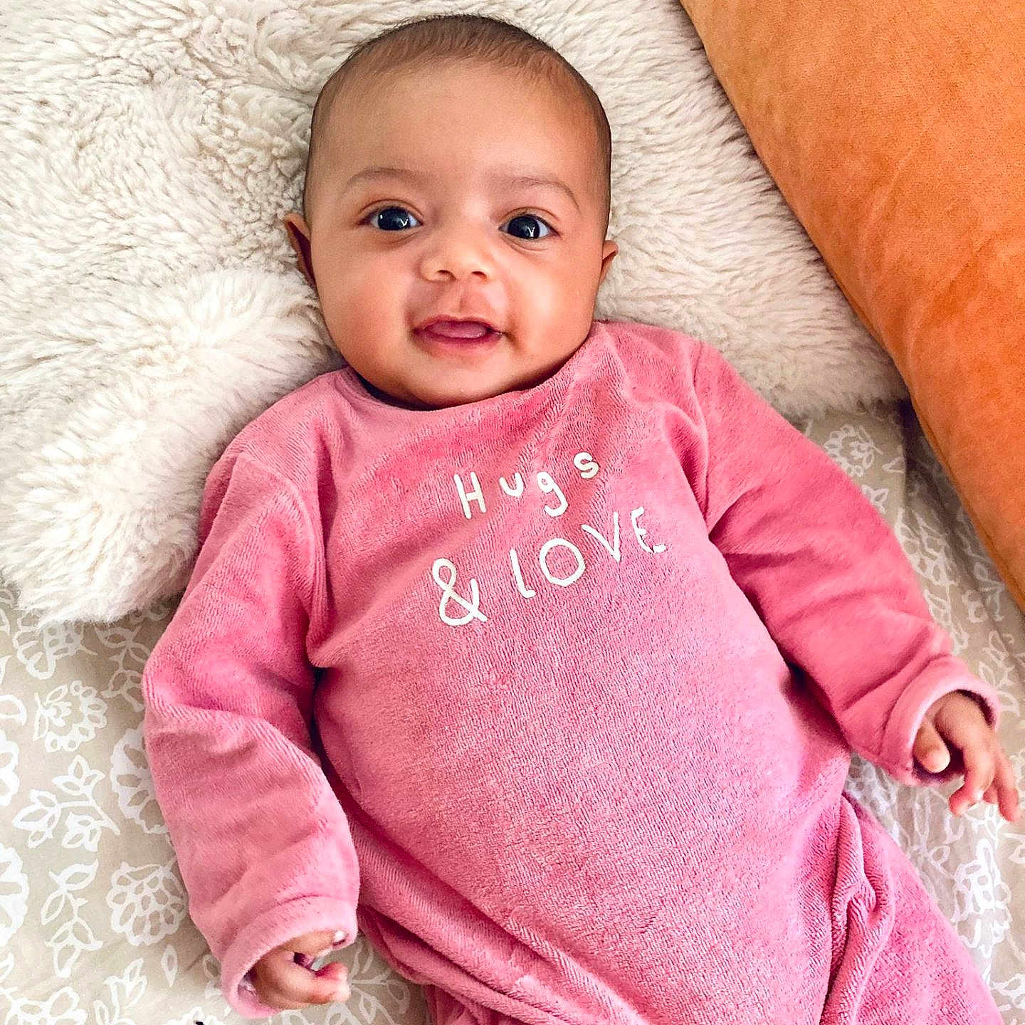 Iris a rejoint le concours — aidez-le/la à gagner de superbes lots ! baby, blanket, child, comfort, cozy, cute, expression, face, happy, head, indoors, infant, love, lying_down, pillow, pink_onesie, portrait, small_hand, smiling, soft_texture