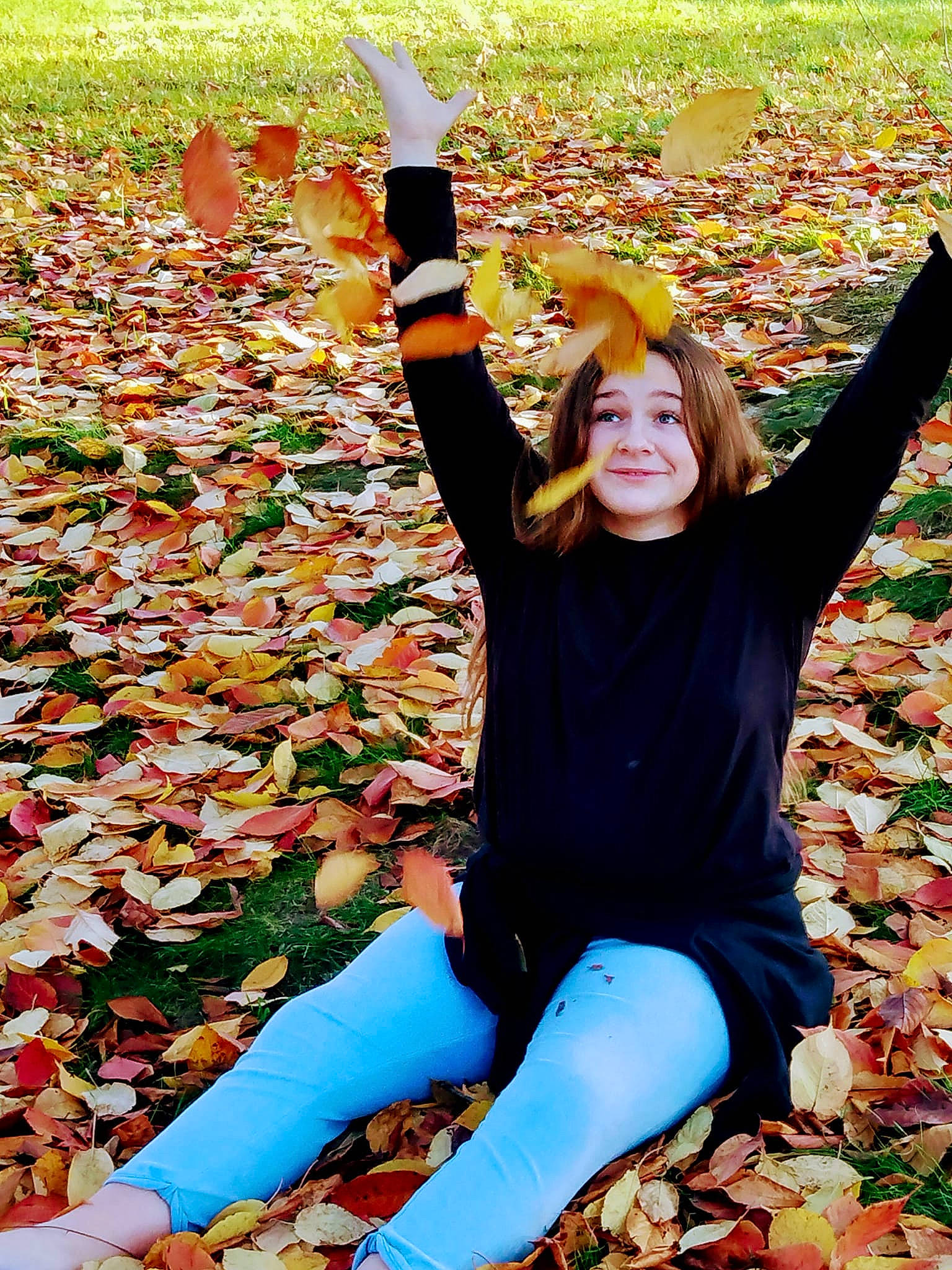 Madison is registered to the contest to win money with this photo: autumn, boot, deciduous, fun, gesture, grass, happy, human_leg, joy, leaf, leg, leisure, people, people_in_nature, person, plant, recreation, sitting, smile, spring