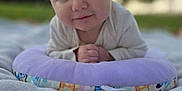 Austyn is registered to the contest to win money with this photo: baby, blanket, blue_eyes, child, closeup, curious, cushion, daylight, face, grass, hands, head, infant, nature, outdoor, portrait, purple, smile, soft, young