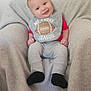 Austyn is registered to the contest to win money with this photo: baby, infant, smiling, bib, football, clothing, gray_blanket, sitting, indoor, cute, happy, child, person, sock, red_shirt, pants, soft_texture, portrait, head, small_hands