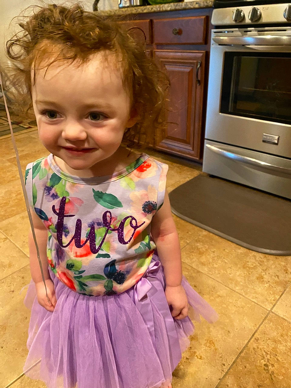 Freya is registered to the contest to win money with this photo: baby_toddler_clothing, cabinetry, child, drawer, fun, hair, happy, hardwood, home_appliance, joy, kitchen, kitchen_appliance, kitchen_stove, microwave_oven, pattern, person, sleeve, smile, stove, t_shirt