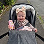 Miley joined the competition — help win amazing prizes! baby, blanket, bow, child, clothing, happy, headband, nature, outdoor, person, phone_case, pink, road, seat_belt, sidewalk, smile, stroller, toy, unicorn, urban