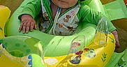 Ledger is registered to the contest to win money with this photo: baby, child, child_in_float, colorful, cute, dinosaur_print, floating, green_clothing, hat, infant, inflatable_float, outdoor, playtime, pool, smiling, summer, sun_hat, sunny_day, water, yellow_canopy