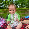 Ledger joined the competition — help win amazing prizes! animal_print, baby, blanket, child, clothing, cute, daylight, foot, forest, greenery, hand, happy, nature, onesie, outdoor, park, person, picnic, sitting, smile