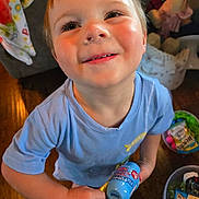Chevy joined the competition — help win amazing prizes! child, smiling, indoor, toy, blue_shirt, floor, wooden_floor, young_child, happy, person, face, play, holding, bottle, clothing, home, colorful, casual, looking_up, cute