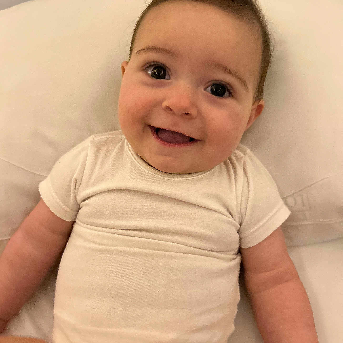 Anastacia a rejoint le concours — aidez-le/la à gagner de superbes lots ! arm, baby, child, cute, expression, eyes, face, happy, head, human, indoor, infant, lying_down, mouth, portrait, skin, smiling, soft, white_onesie, young_child