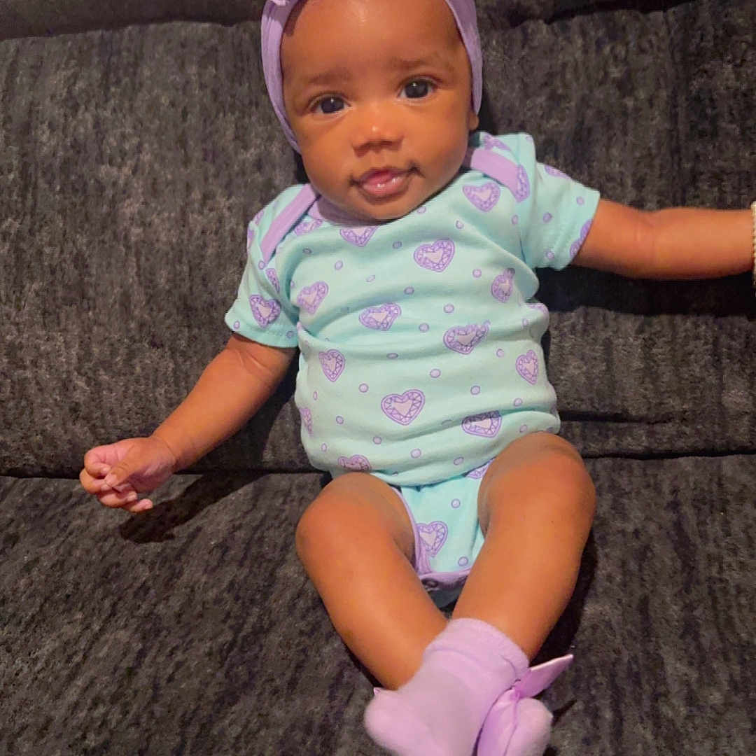 Kali joined the competition — help win amazing prizes! baby, bonnet, clothing, couch, diaper, dress, face, footwear, furniture, hardwood, hat, head, hosiery, person, photography, portrait, shoe, sitting, sock, wood