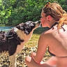 dog, person, river, rocks, nature, outdoor, water, trees, sunlight, black_and_white, summer, sitting, pet, animal, friendship, love, leisure, casual, bare_shoulders, bond