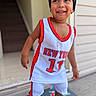 child, toddler, smiling, portrait, basketball_jersey, sportswear, beanie, sneakers, cross_necklace, outdoor, doorway, house, doormat, standing, happy, face, fashion, athletic, number_17, new_york