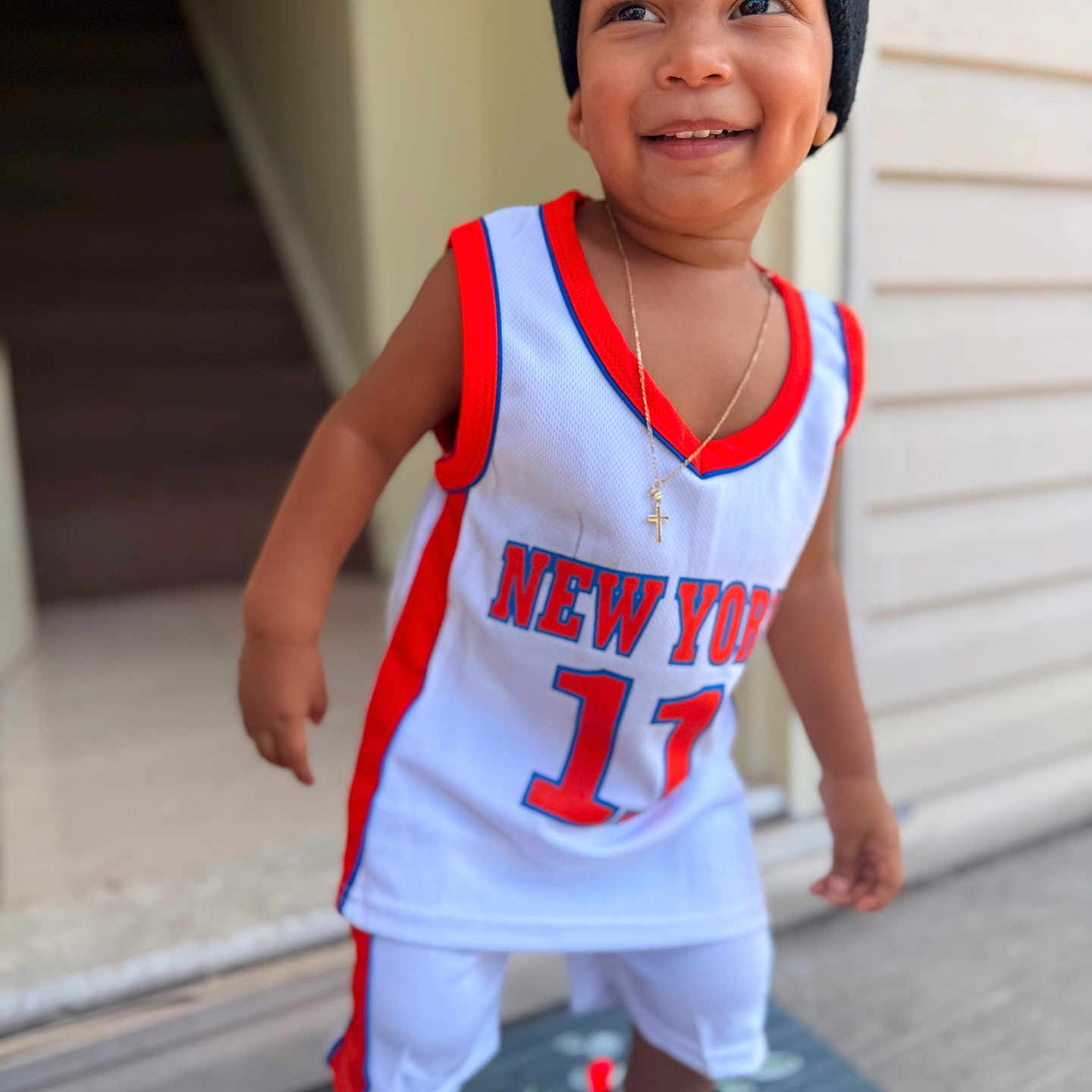 Ryan Nathael joined the competition — help win amazing prizes! child, toddler, smiling, portrait, basketball_jersey, sportswear, beanie, sneakers, cross_necklace, outdoor, doorway, house, doormat, standing, happy, face, fashion, athletic, number_17, new_york
