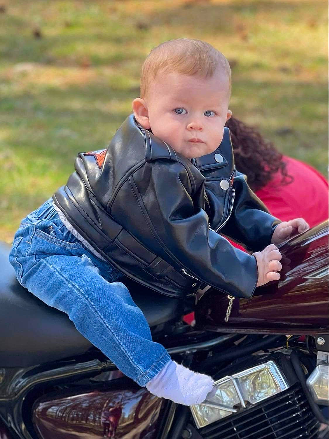 Bellamy is registered to the contest to win money with this photo: automotive_design, automotive_exterior, automotive_lighting, automotive_tire, bag, bumper, chair, grass, happy, hood, human_body, jacket, leisure, luggage_and_bags, motor_vehicle, motorcycle, outerwear, people_in_nature, person, toddler